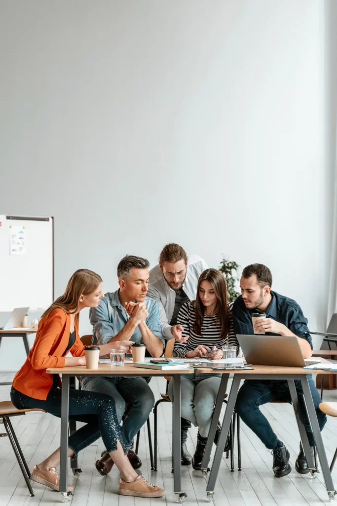 Menschen sitzen um einen Tisch und halten ein Meeting ab.