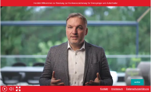 Mann in grauem Sakko (Tobias Tobisch) spricht in einem Video über Krankenversicherung Schweiz für Grenzgänger.