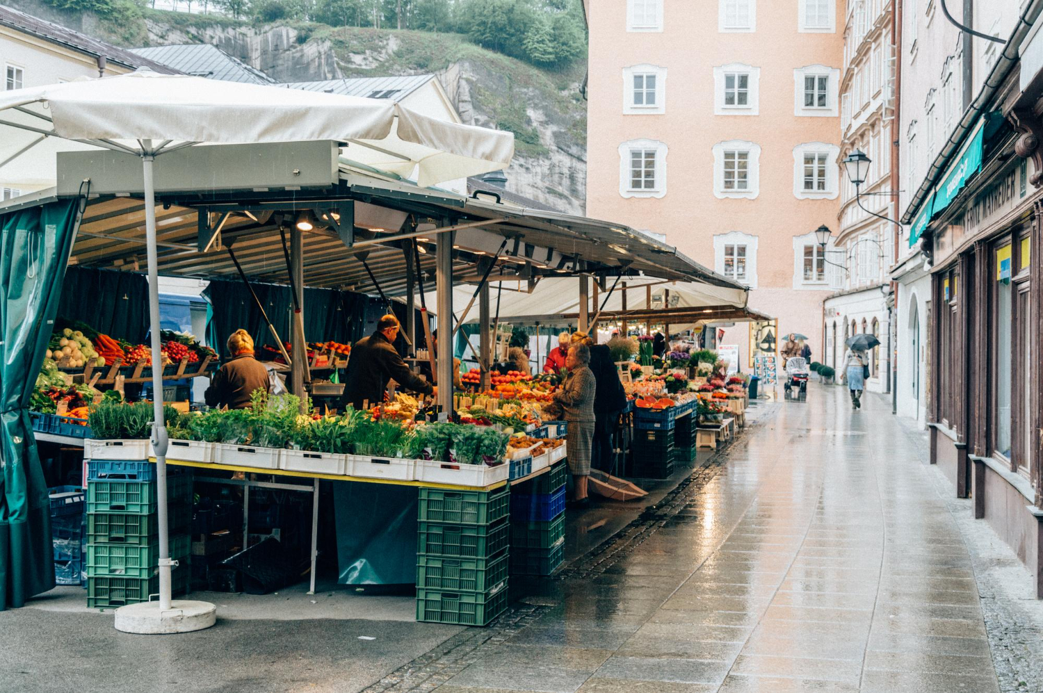 Gemüsestand auf einem Wochenmarkt in der Altstadt – ein Beispiel für alltägliche Ausgaben und die hohen Lebenshaltungskosten Schweiz im Alltag.